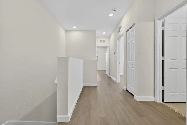 a view of a hallway with wooden floor