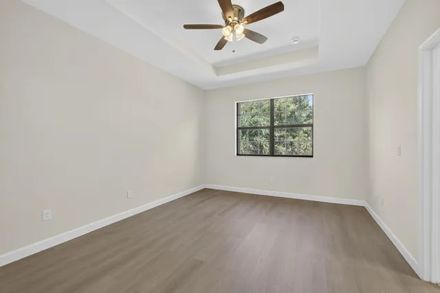 an empty room with a window and a ceiling fan