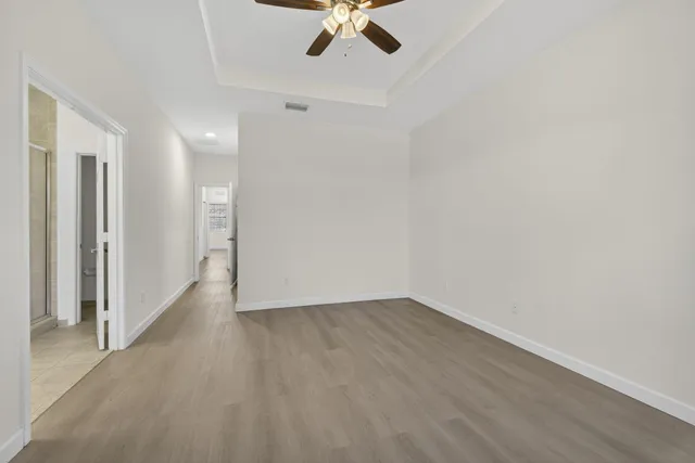 wooden floor in an empty room with a ceiling fan