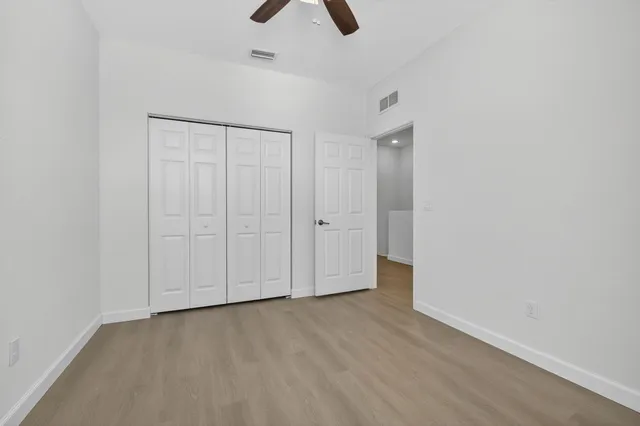 an empty room with closet and windows
