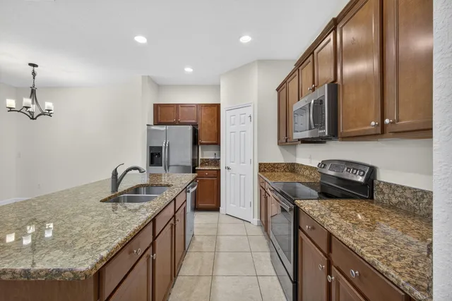 a kitchen with stainless steel appliances granite countertop a sink stove and refrigerator