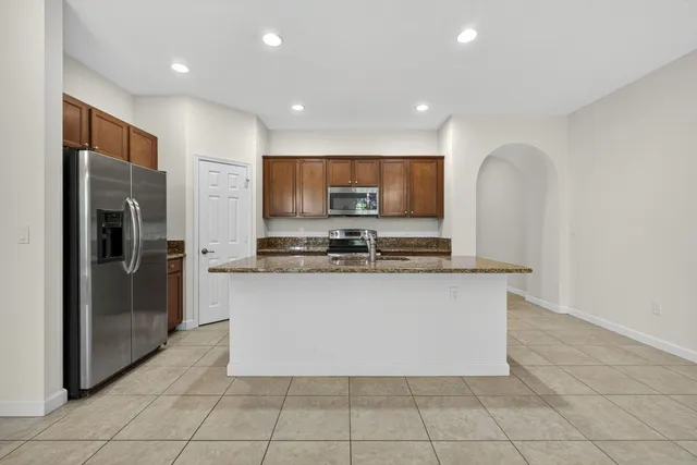 a kitchen with stainless steel appliances granite countertop a refrigerator and a stove