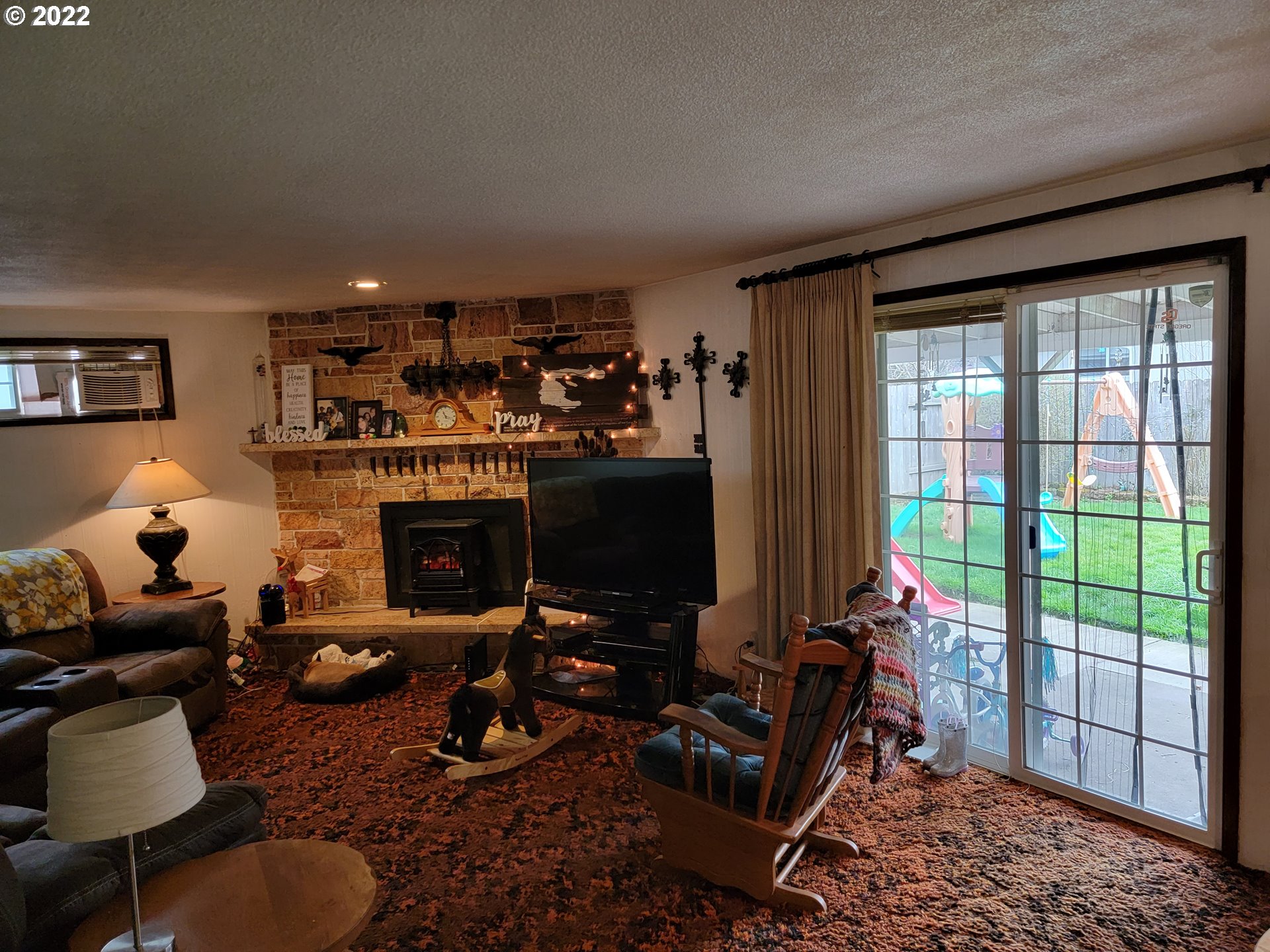 2287 8th Street Springfield, OR 97477 - Photo 5 of 18 a living room with furniture a lamp and a fireplace