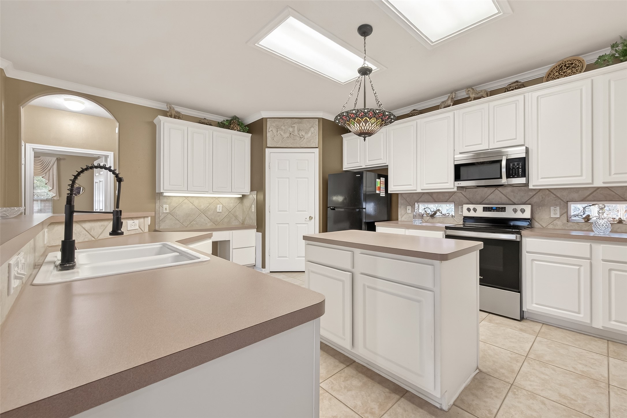 71 Ember Pines Court Conroe, TX 77384 - Photo 12 of 29 a kitchen with granite countertop a sink stainless steel appliances and white cabinets