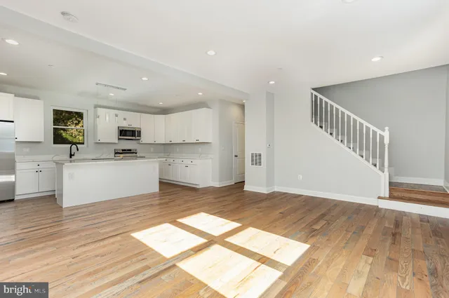 a kitchen with stainless steel appliances granite countertop grey cabinets a stove a sink and a microwave