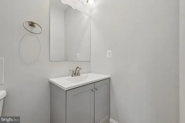 a bathroom with a granite countertop sink mirror vanity and toilet