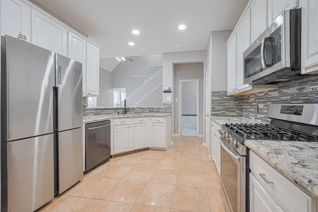a kitchen with stainless steel appliances granite countertop a refrigerator stove and microwave