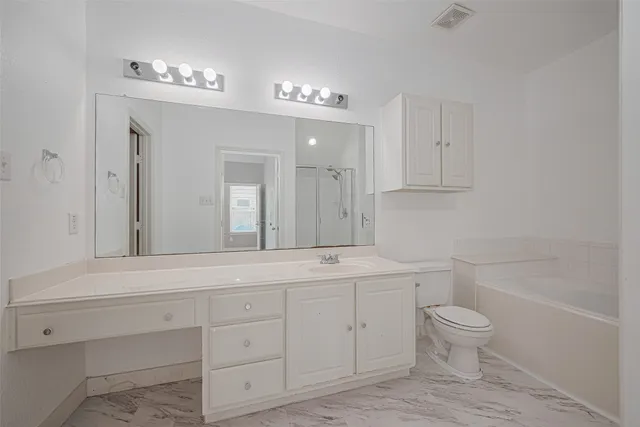 a bathroom with a double vanity sink a toilet and a mirror