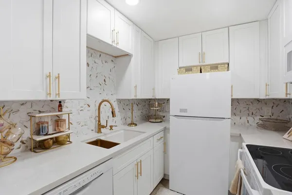 a view of a kitchen with sink and refrigerator