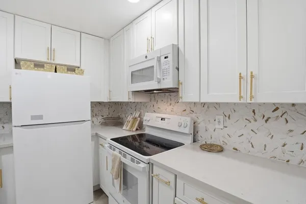 a view of a kitchen with sink and refrigerator