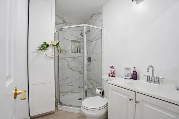 a bathroom with a granite countertop sink a toilet and shower