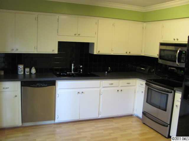 3800 Churchill Road, Unit 1 Charlotte, NC 28211 - Photo 6 of 16 a kitchen with granite countertop white cabinets and black appliances
