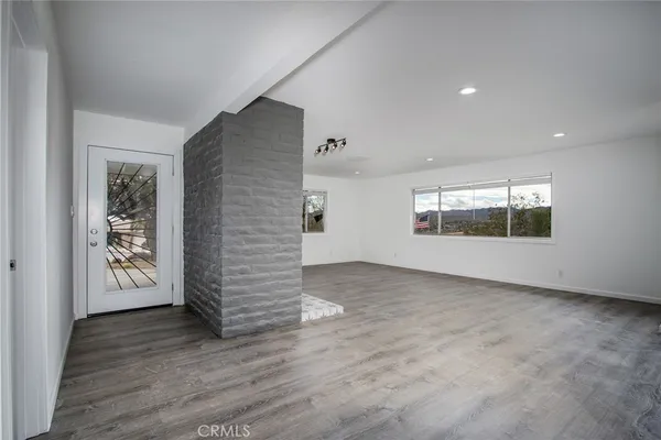 a view of empty room with wooden floor and fireplace