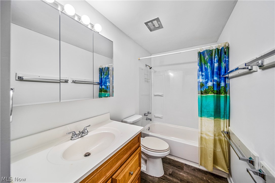 1781 Falkirk Road Madison, OH 44057 - Photo 9 of 25 Full bathroom with shower / bath combo, vanity, toilet, and hardwood / wood-style flooring