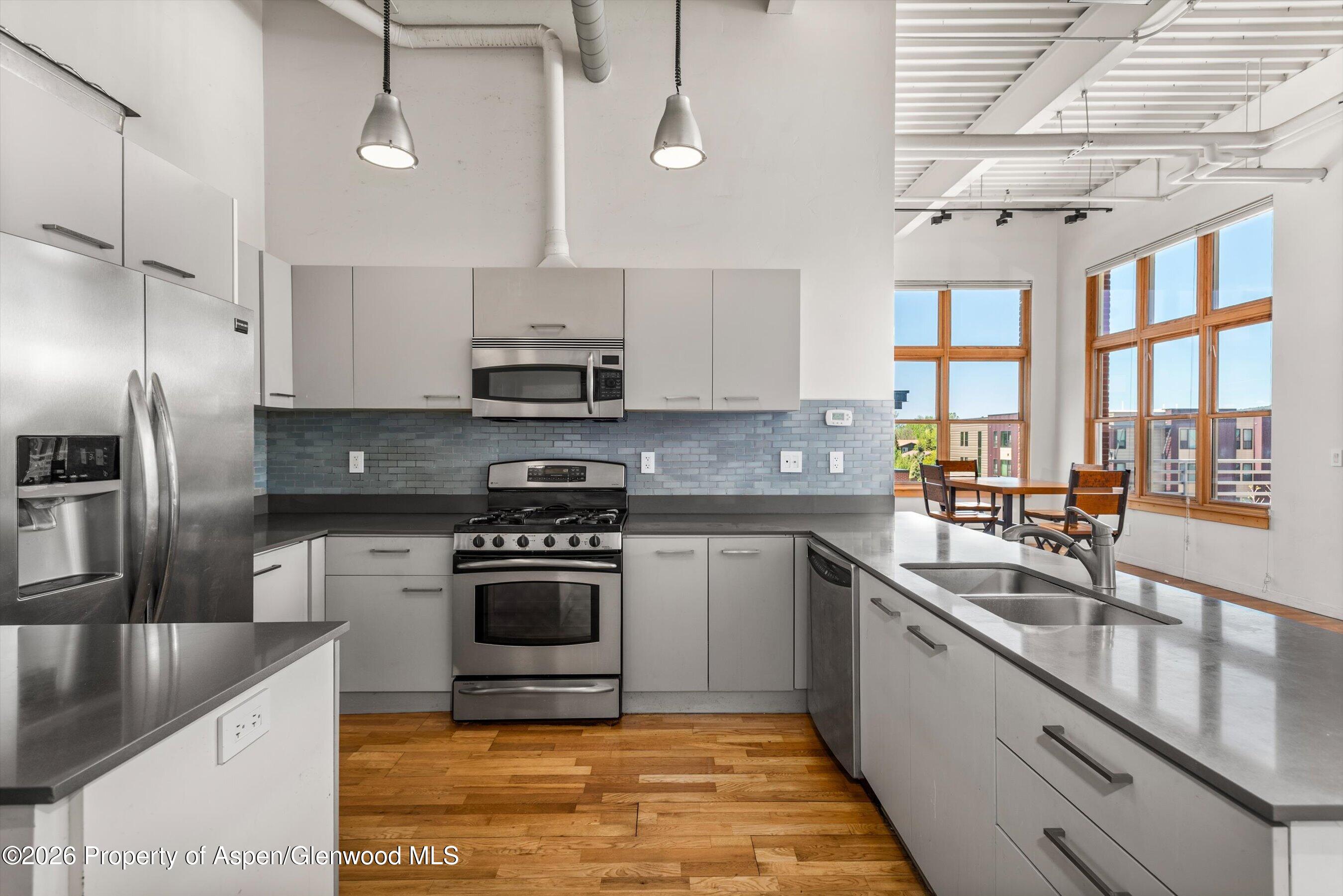 231 Robinson Street, Unit 312 Basalt, CO 81621 - Photo 12 of 18 a kitchen with stainless steel appliances granite countertop a sink a stove and a refrigerator