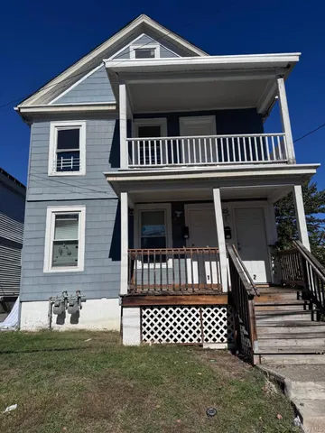 a view of a house with a deck and a yard