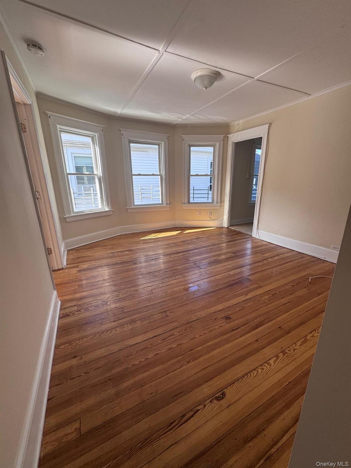 25 Lent Street, Unit 2 Poughkeepsie, NY 12601 - Photo 4 of 14 a view of an empty room with wooden floor and a window