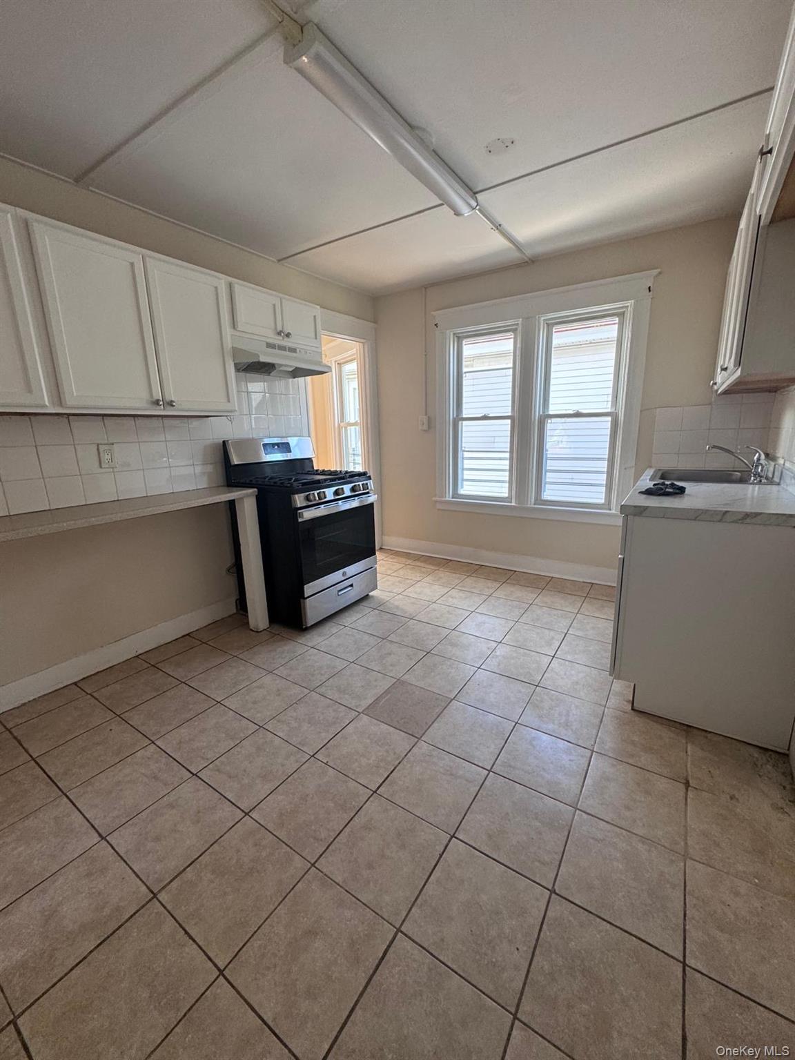 25 Lent Street, Unit 2 Poughkeepsie, NY 12601 - Photo 10 of 14 a kitchen with granite countertop a stove a sink and a refrigerator