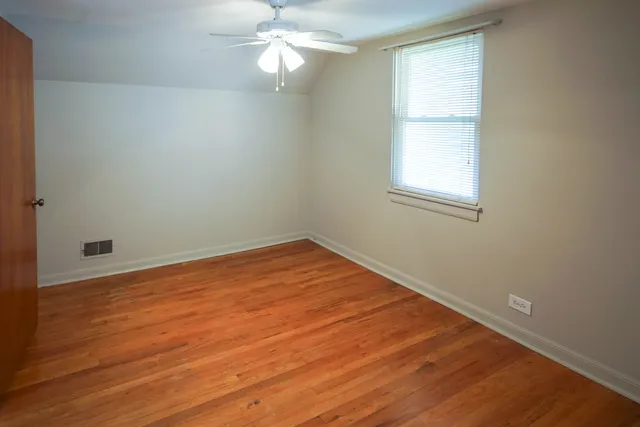 a view of a room with wooden floor and fan