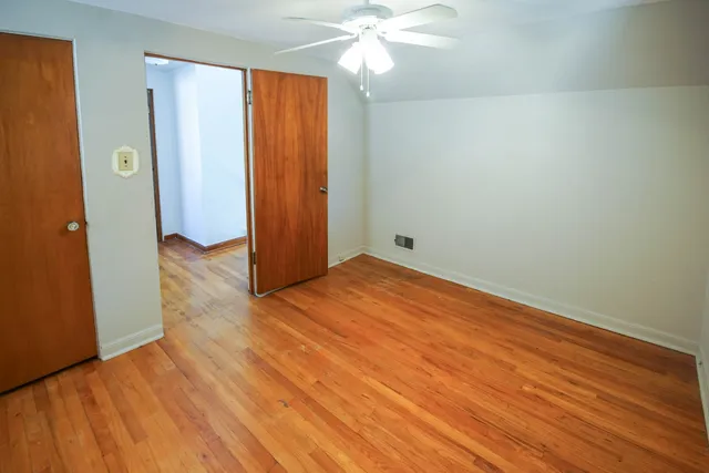 a view of empty room with window and wooden floor