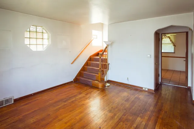 a view of empty room with wooden floor