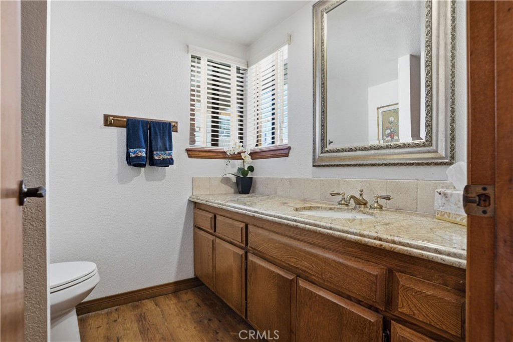 30026 Big Range Road Canyon Lake, CA 92587 - Photo 12 of 48 a bathroom with a granite countertop toilet sink and mirror