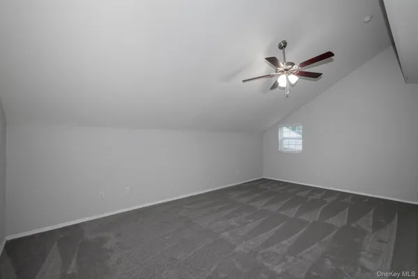 an empty room with a window and ceiling fan