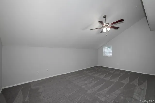 an empty room with a window and ceiling fan