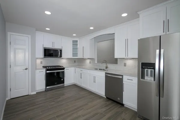 a kitchen with stainless steel appliances granite countertop a refrigerator and a stove top oven
