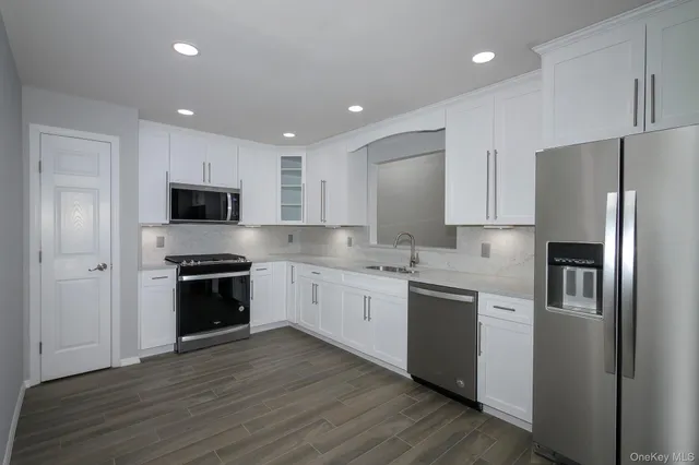 a kitchen with stainless steel appliances granite countertop a refrigerator and a stove top oven