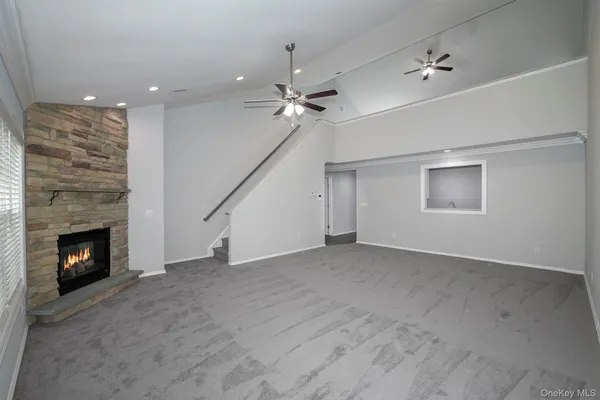 an empty room with windows and fireplace