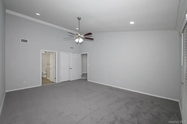 a view of an empty room with a chandelier fan