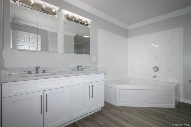 a bathroom with a granite countertop sink mirror and a bathtub