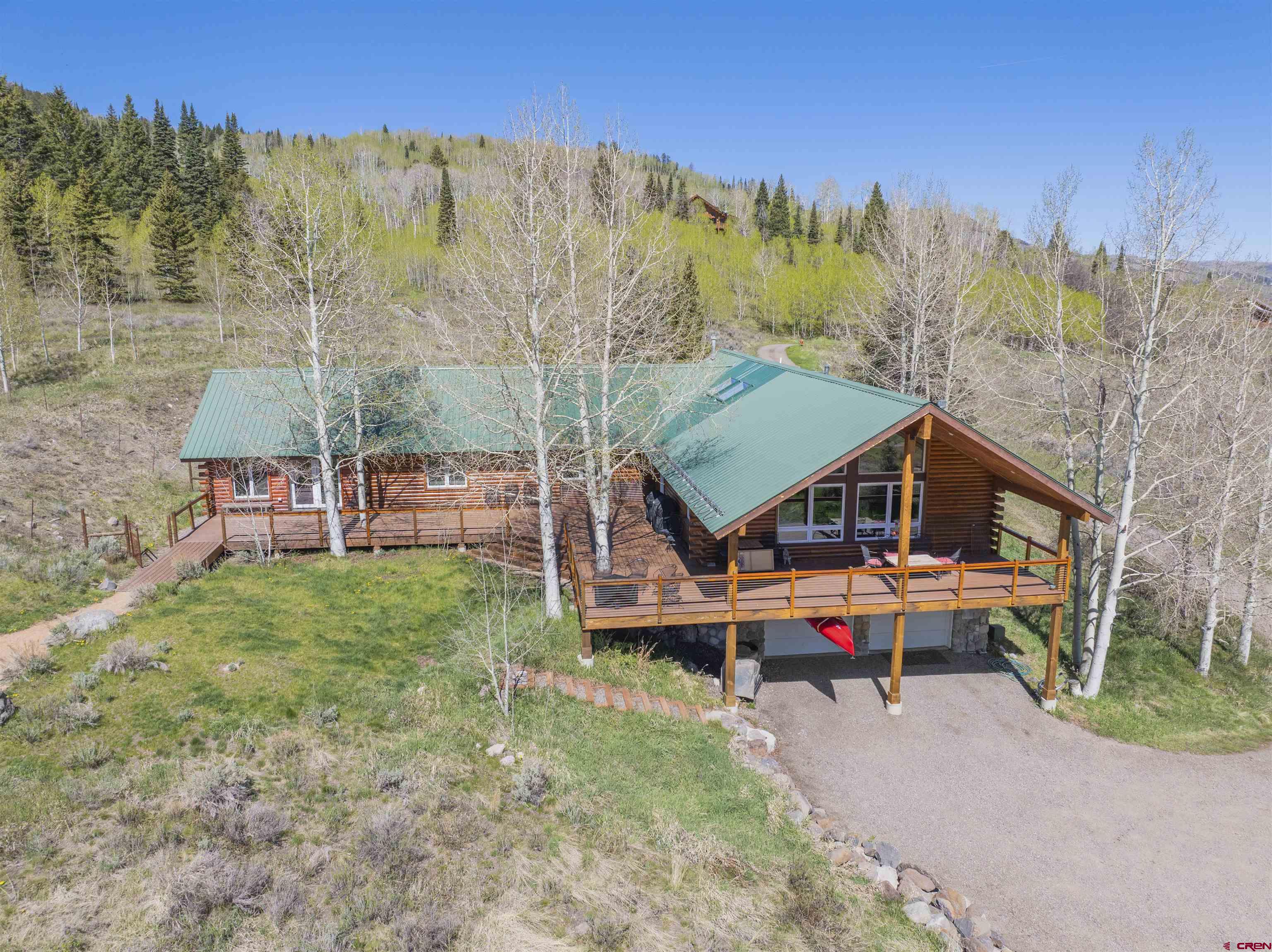 684 Falcon Way Montrose, CO 81403 - Photo 2 of 43 a roof deck with table and chairs under an umbrella