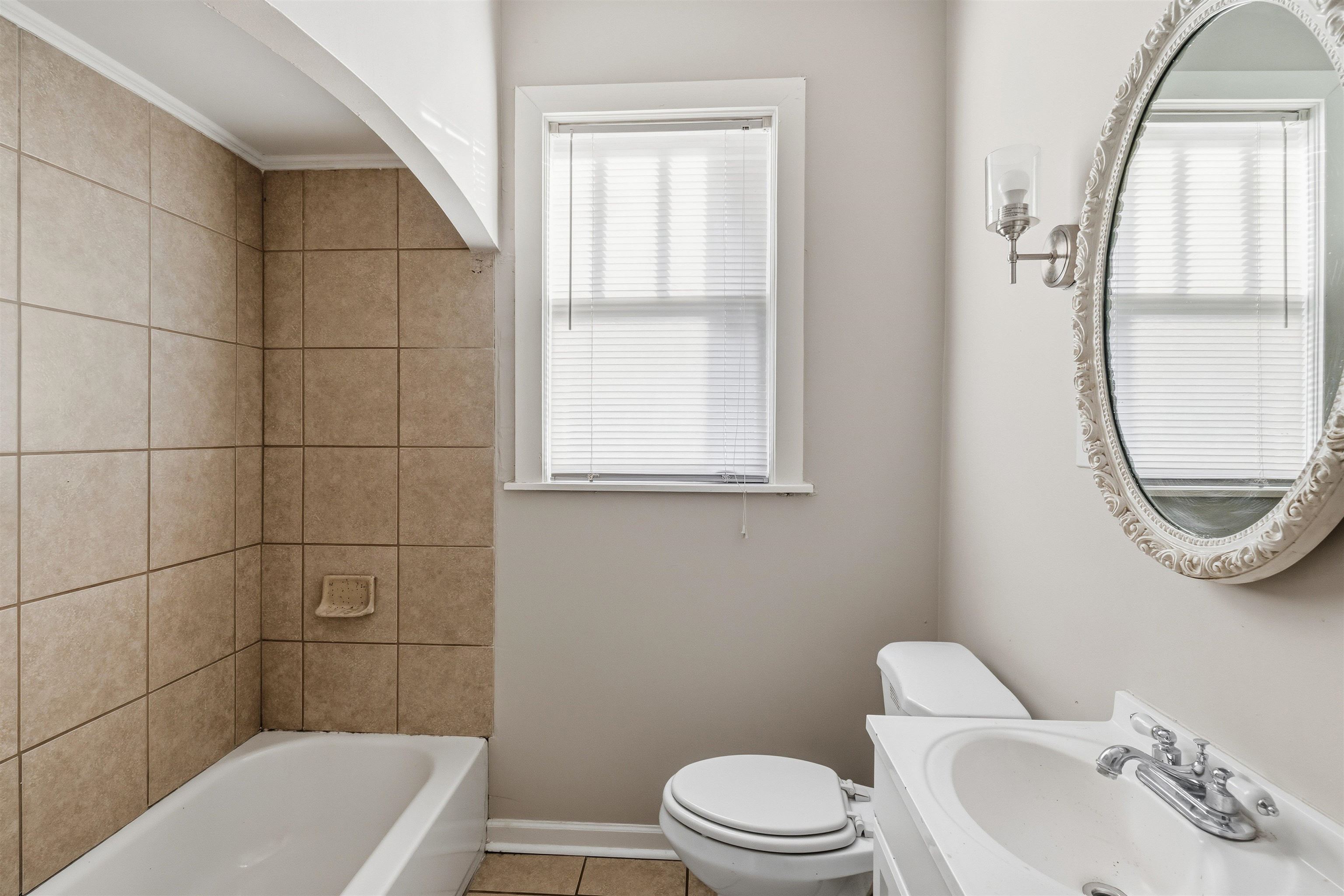 871 University Street Memphis, TN 38107 - Photo 15 of 26 a bathroom with a sink a toilet and a mirror