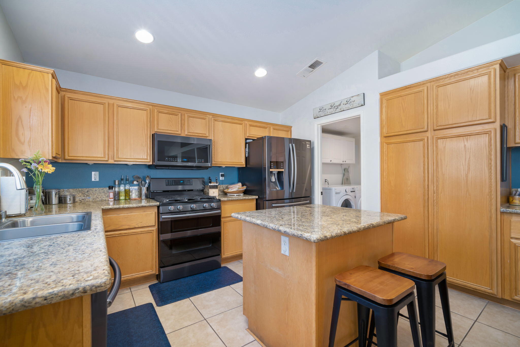 79350 Paseo Del Rey La Quinta, CA 92253 - Photo 18 of 41 a kitchen with stainless steel appliances granite countertop a stove top oven a sink dishwasher a dining table and chairs with wooden floor