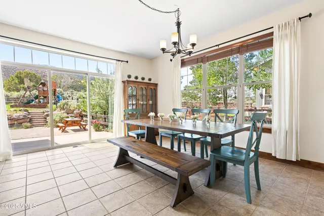a dining room with furniture a chandelier and wooden floor