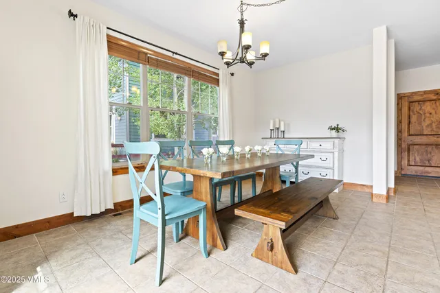 a living room with dining table and a floor to ceiling window