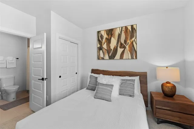 a bedroom with a bed and a painting on the wall