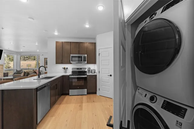 a kitchen with stainless steel appliances granite countertop a sink a stove and a refrigerator