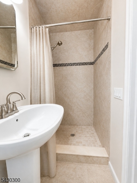 25 Spring Street, Unit A Millburn, NJ 07041 - Photo 10 of 21 a bathroom with a sink a shower and a mirror