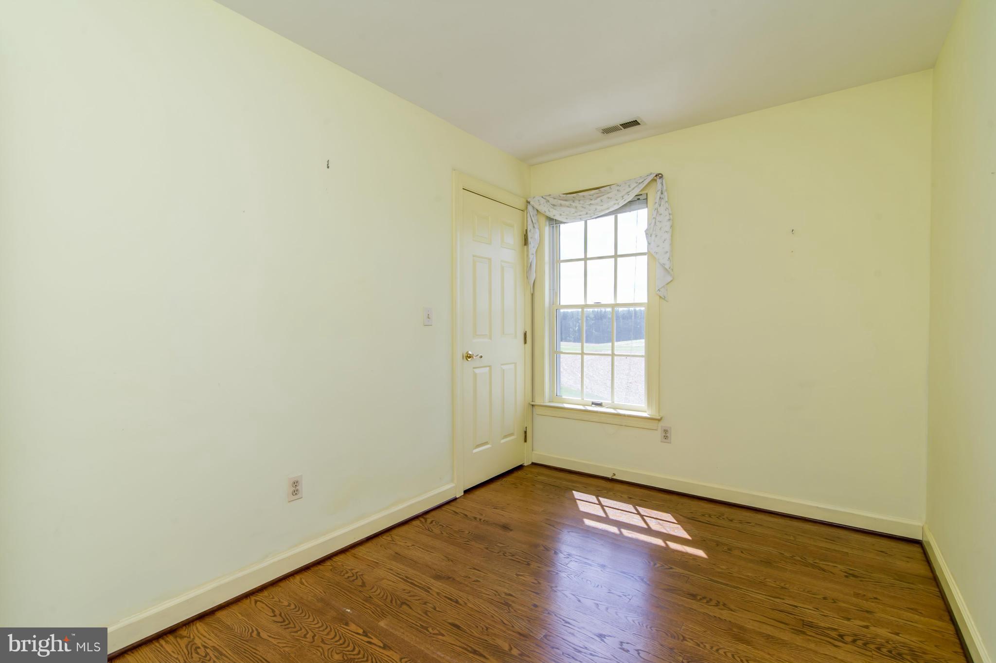 17615 Falls Road Upperco, MD 21155 - Photo 20 of 26 a view of an empty room with wooden floor and a window