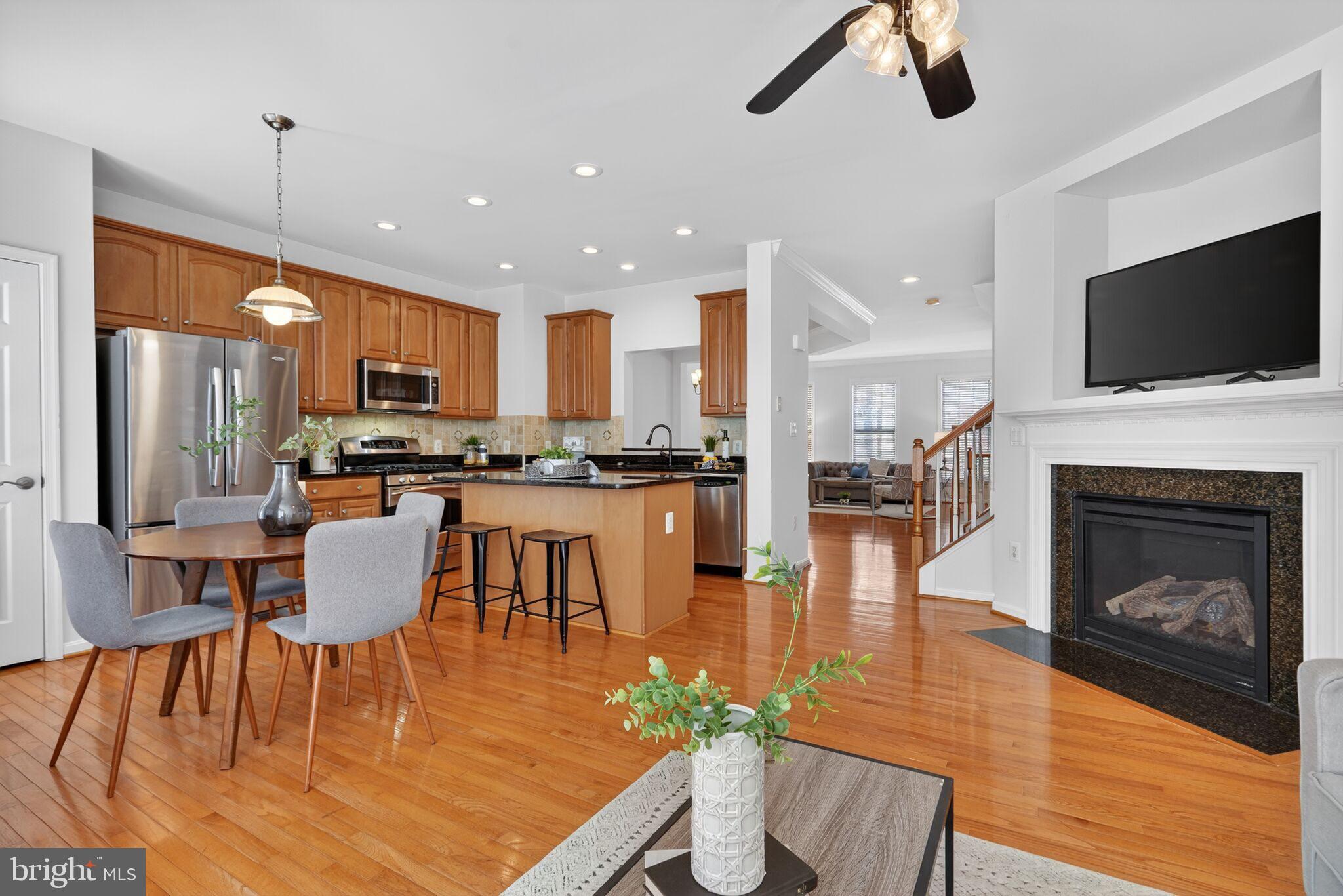 9144 Furey Road Lorton, VA 22079 - Photo 10 of 28 a kitchen with a table chairs refrigerator and a fireplace