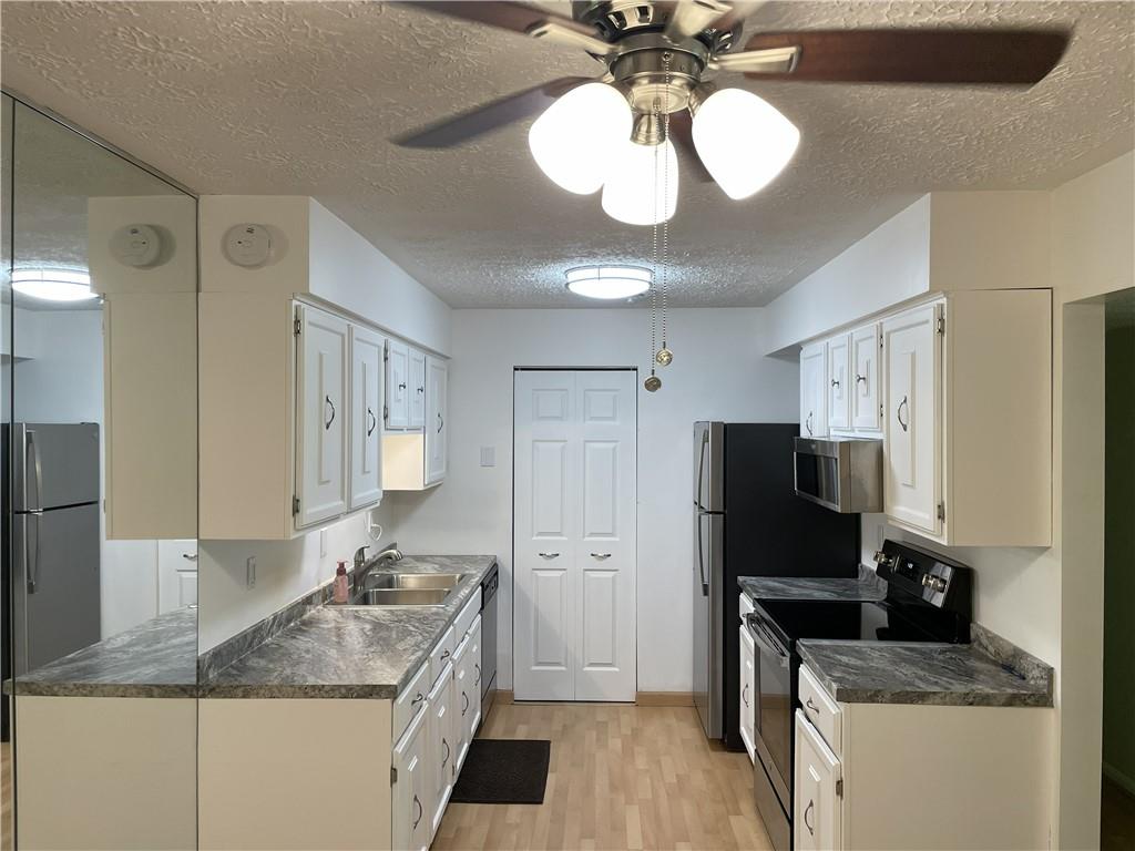 300 Gilkeson Road, Unit C7 Pittsburgh, PA 15228 - Photo 4 of 13 a kitchen with a sink stainless steel appliances a counter space and cabinets