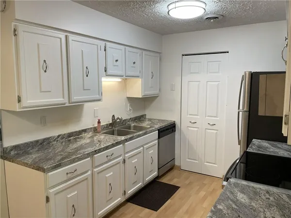 a kitchen with stainless steel appliances granite countertop a stove a sink and a refrigerator