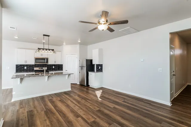 a view of kitchen with sink microwave and refrigerator