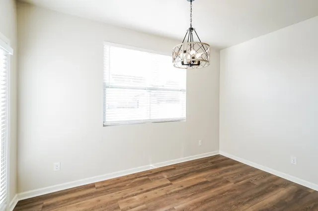 a view of a room with wooden floor chandelier and window