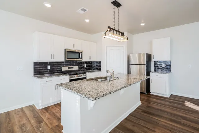 a kitchen with stainless steel appliances granite countertop a sink refrigerator and microwave