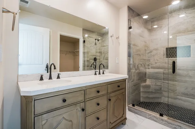 a bathroom with a shower sink and mirror