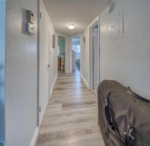 a view of a hallway with wooden floor and staircase